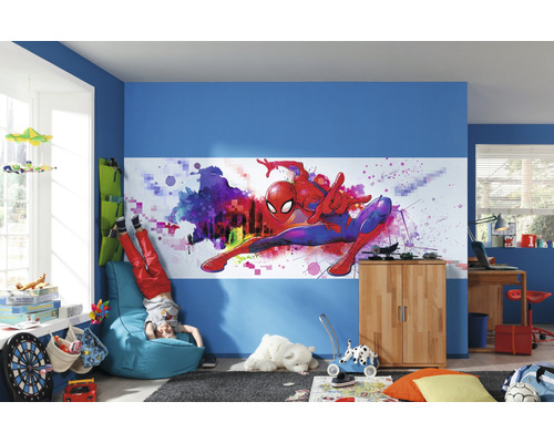 Cameră de copii decorată cu pictură murală Spider-Man, pereți albaștri și diverse piese de mobilier.