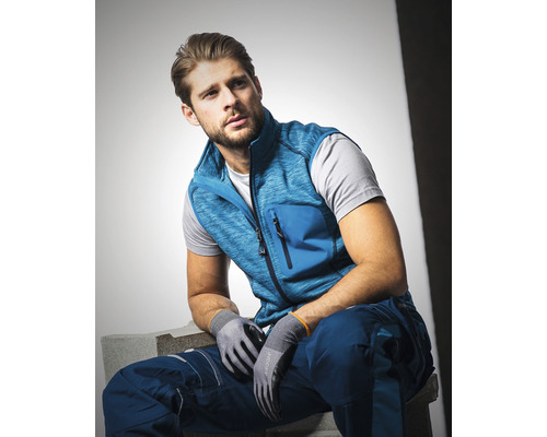 Bărbat cu vestă de lucru, pantaloni de lucru și mănuși de lucru