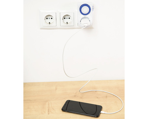 Un smartphone este încărcat printr-o priză cu un temporizator.