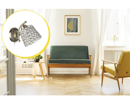 Interior cu canapea, fotoliu și o lampă de perete cu decor din cristal