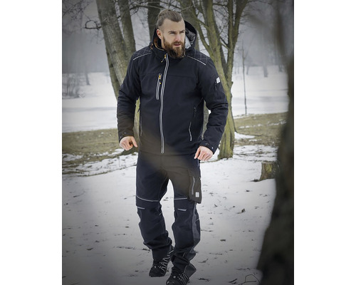 Bărbat în haine de lucru compuse din jachetă și pantaloni iarna