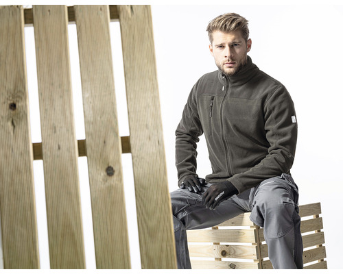 Bărbat în haine de lucru așezat pe un palet