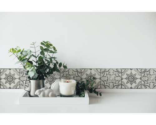 Bordură de perete cu model floral, eucalipt într-un ulcior și lumânare pe o tavă