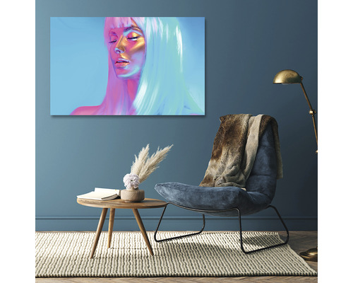 Pânză decorativă cu portretul unei femei într-un living cu fotoliu și măsuță laterală.