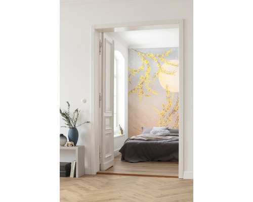 Un dormitor cu tapet de perete cu modele florale galbene este vizibil printr-o ușă deschisă.