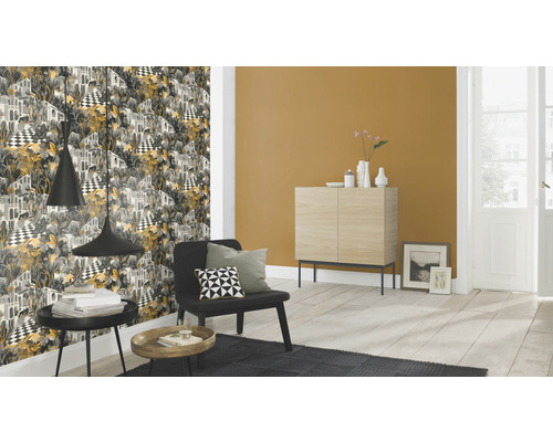 Living cu tapet cu model, fotoliu și măsuțe laterale.