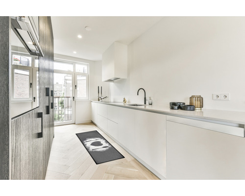 Bucătărie modernă cu covor de bucătărie, dulapuri albe și podea din lemn