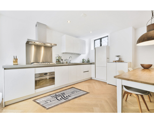 Bucătărie modernă cu dulapuri albe și un covoraș cu motiv de cafea