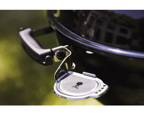 Imagine detaliată a unui grătar sferic cu colector de cenușă deschis și logo Weber