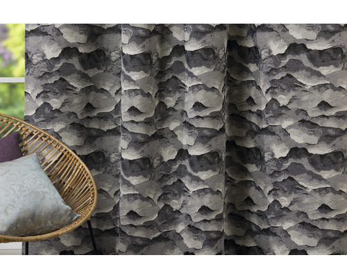 Șaluri decorative cu motiv montan lângă un scaun de ratan