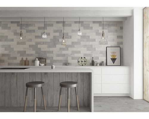 Bucătărie modernă cu perete cu gresie, insulă de bucătărie și scaune de bar.