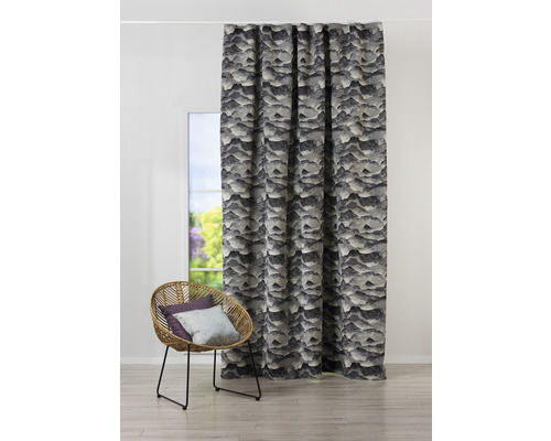 Perdele decorative în fața unei ferestre și a unui fotoliu