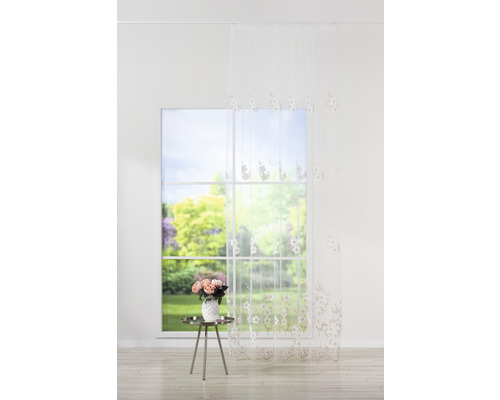 Cortină cu model floral în fața ferestrei