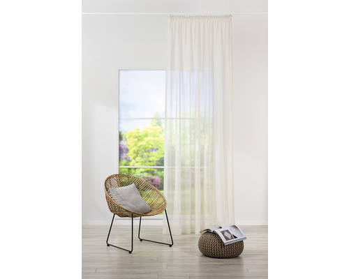 Exemplu de amenajare interioară cu scaun, perdea și pernă de șezut într-o cameră luminoasă