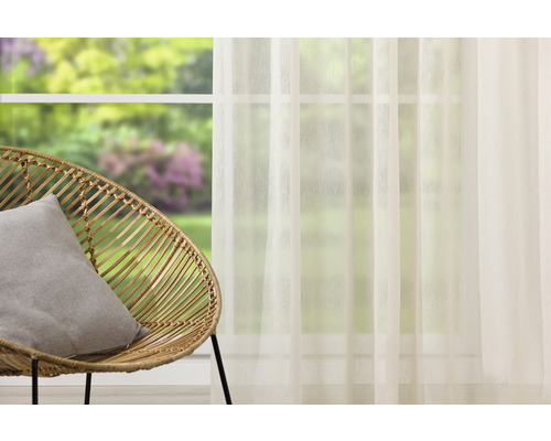 Cameră luminoasă decorativă cu fotoliu din ratan, pernă și perdea de fereastră