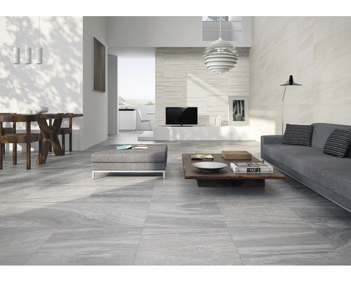 Living modern cu gresie gri, canapea și masă de sufragerie.