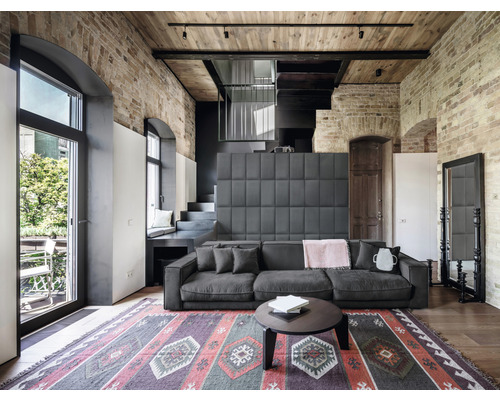 Living cu canapea, covor și perete de cărămidă