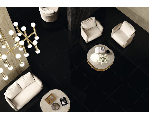 Cameră de zi cu gresie neagră, canapea, fotolii și măsuțe de cafea.