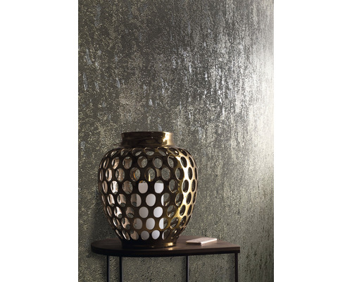 Lanternă aurie cu lumânare pe o masă în fața unui perete texturat