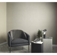 Idee de amenajare cu fotoliu, masă și lampă în fața unui perete simplu