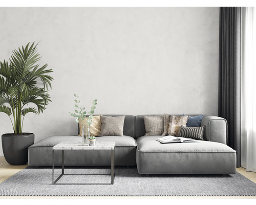 Cameră de zi cu canapea de colț gri, măsuță de cafea cu blat de marmură și plantă de interior