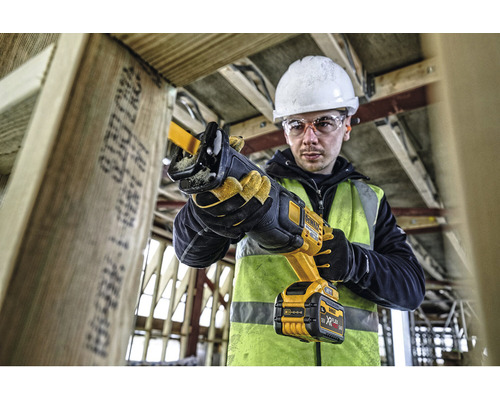 Meșter care lucrează cu un fierăstrău sabie DeWalt pe un șantier.