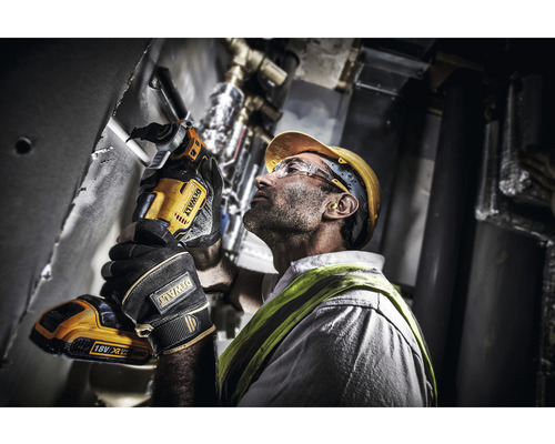 Artizan folosind o unealtă de tăiat țevi fără fir DeWalt pe o instalație.