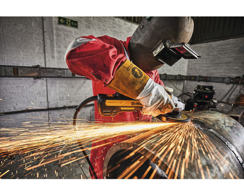 Un bărbat șlefuiește o țeavă metalică cu un polizor unghiular DeWalt, în timp ce sar scântei.