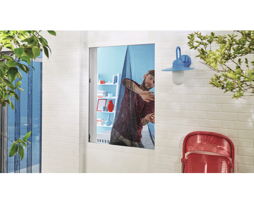 Cadru exterior cu o persoană care fixează o plasă de țânțari pe un toc de fereastră.