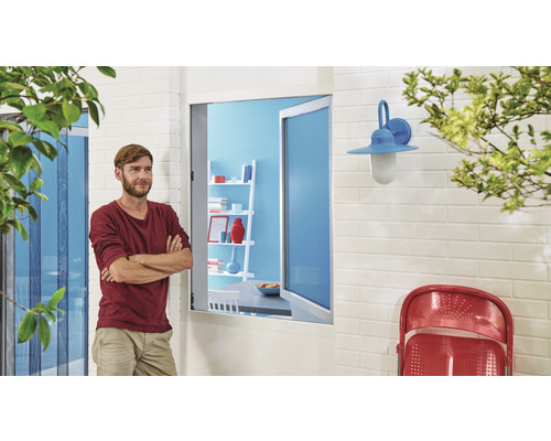 Bărbat stând în fața unei case cu plasă de protecție împotriva insectelor și lampă de exterior