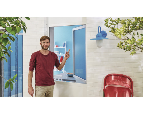 Bărbat arătând spre o plasă de țânțari pentru ferestre într-o zonă de locuit