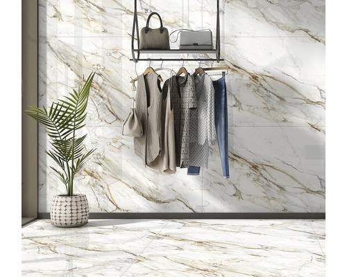 Vedere a camerei cu plăci ceramice cu aspect de marmură, suport pentru haine cu haine și plantă la ghiveci