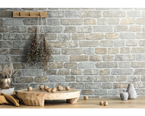 Decor de perete cu aspect de piatră, scândură de lemn, decorațiuni și nuci pe masă din lemn