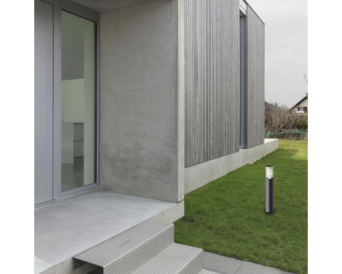 Vedere exterioară a unei case cu o lumină de cale în grădină