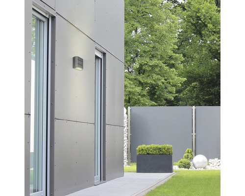 Exteriorul unei case moderne cu iluminat de faţadă, ferestre şi elemente de grădină