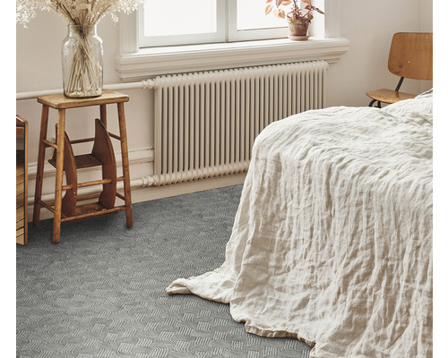 Dormitor cu pat, calorifer, taburet din lemn și pardoseală texturată