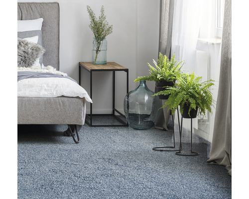 Dormitor cu pat, noptieră, plante de interior și covor