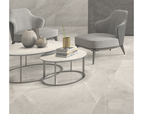 Scenă cu fotolii, măsuțe de cafea și plăci de pardoseală cu aspect de marmură.