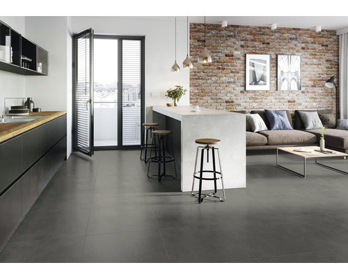 Living modern cu zonă de bucătărie, gresie gri și perete de cărămidă.