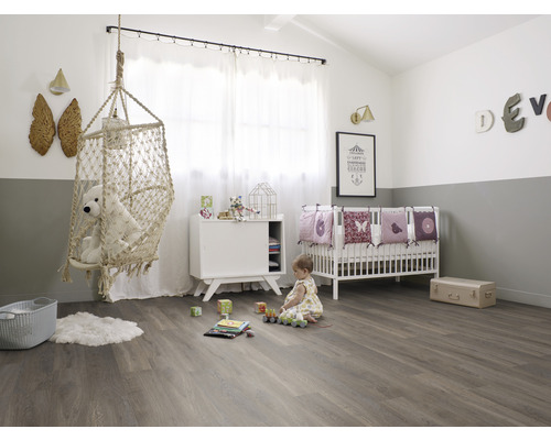 Cameră de copii cu scaun suspendat, pătuț și jucării pe podea de lemn