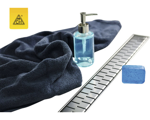 Scenă cu rigolă de duș, prosop, săpun și dispenser de săpun