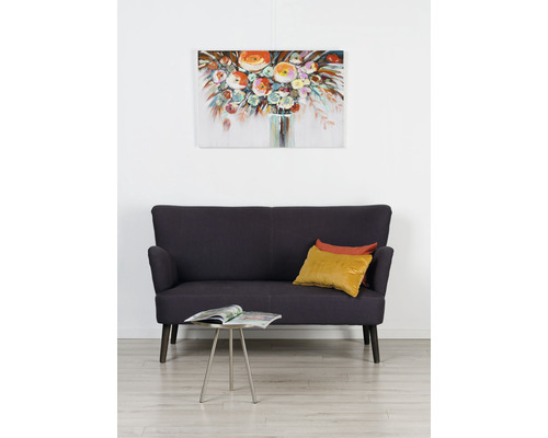 Imagine de sufragerie cu canapea, perne, măsuță laterală și tablou cu flori pe perete