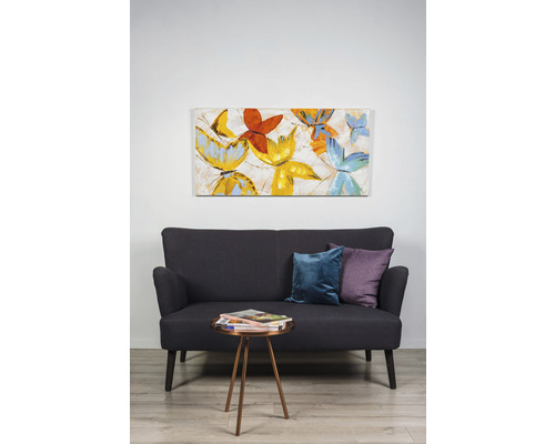 Cameră de zi cu canapea, perne, măsuță laterală și pictură murală