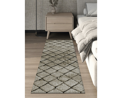 Covor cu model în romburi în dormitor, lângă pat și noptieră