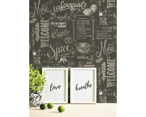 Tapetă decorativă tip tablă cu inscripții cu cretă într-o cameră cu o plantă în ghiveci și rame foto