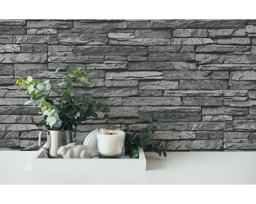 Decorare perete cu tapet aspect piatră, decorare cu lumânare și plantă verde