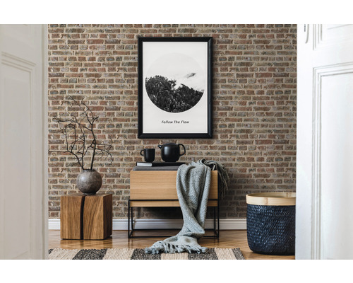 Living decorativ cu tapet cu model de cărămidă, comodă din lemn și accesorii asortate.