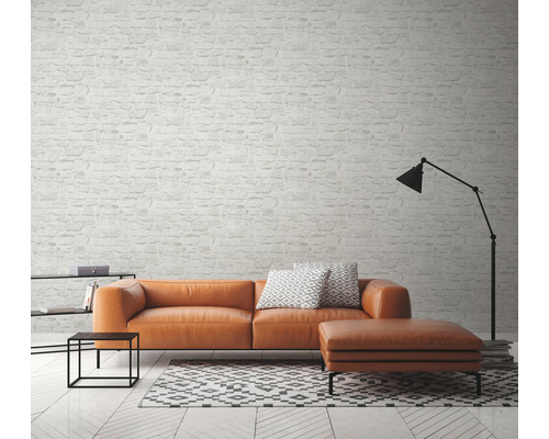 Living cu canapea, taburet, lampă și tapet cu model de cărămidă