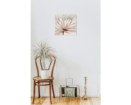 Tablou decorativ cu flori pe un perete deasupra unui scaun cu o plantă