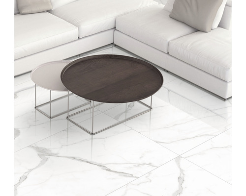 Spațiu de locuit luminos cu canapea albă, măsuțe de cafea și plăci de gresie cu aspect de marmură